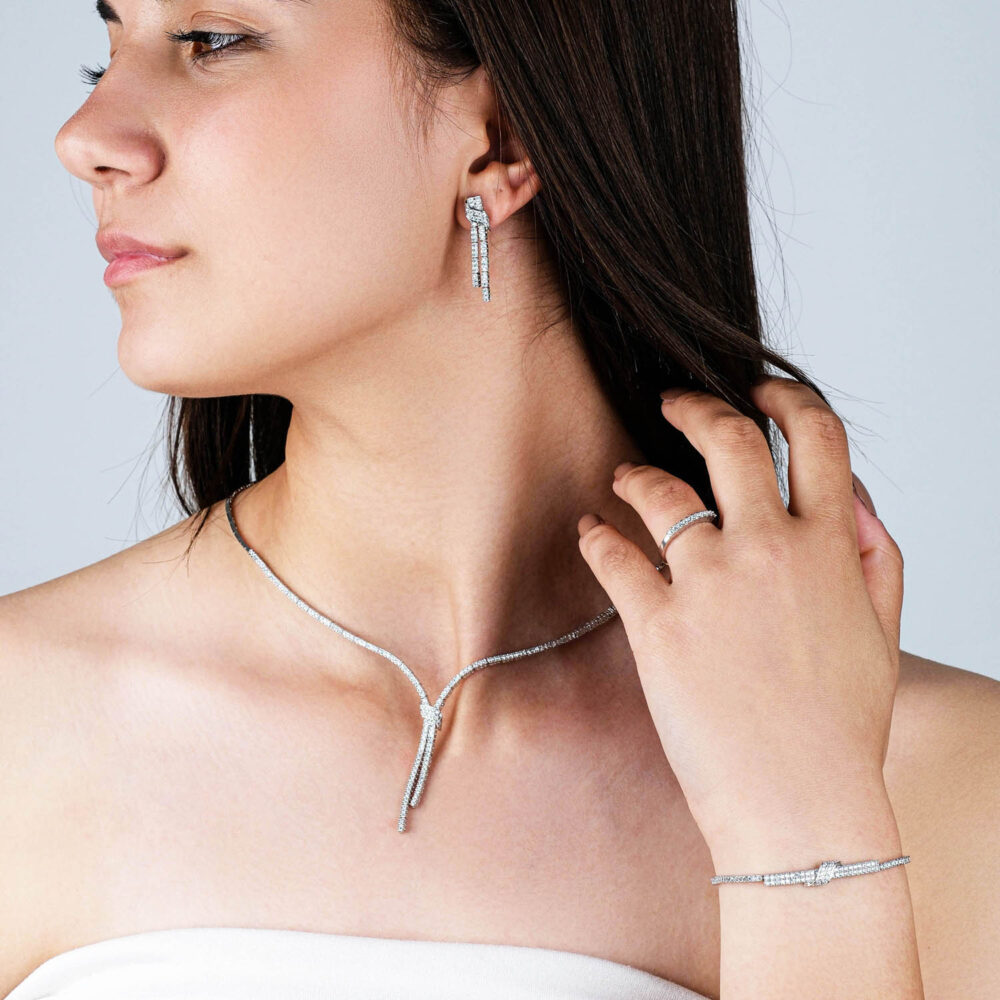 Complete silver tennis jewelry set with zircon necklace, bracelet, ring, and drop earrings on black background
