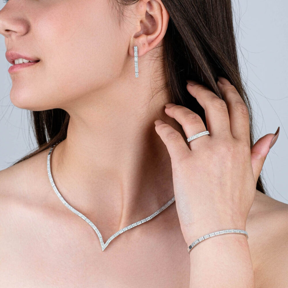 Silver waterway jewelry set with V-shape zircon necklace, bracelet, and drop earrings on model