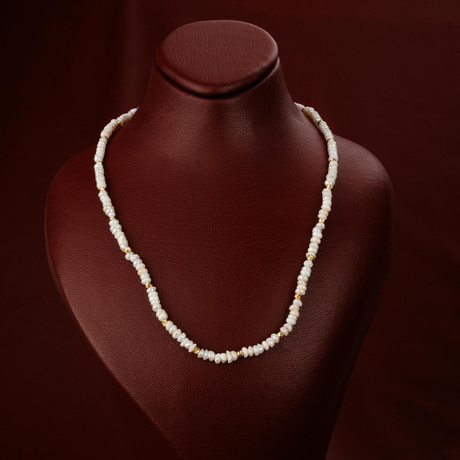 winzige-suesswasserperlen-halskette-gold-stahl Zarte Halskette aus winzigen Süßwasserperlen mit goldfarbenen Stahlperlen auf Display