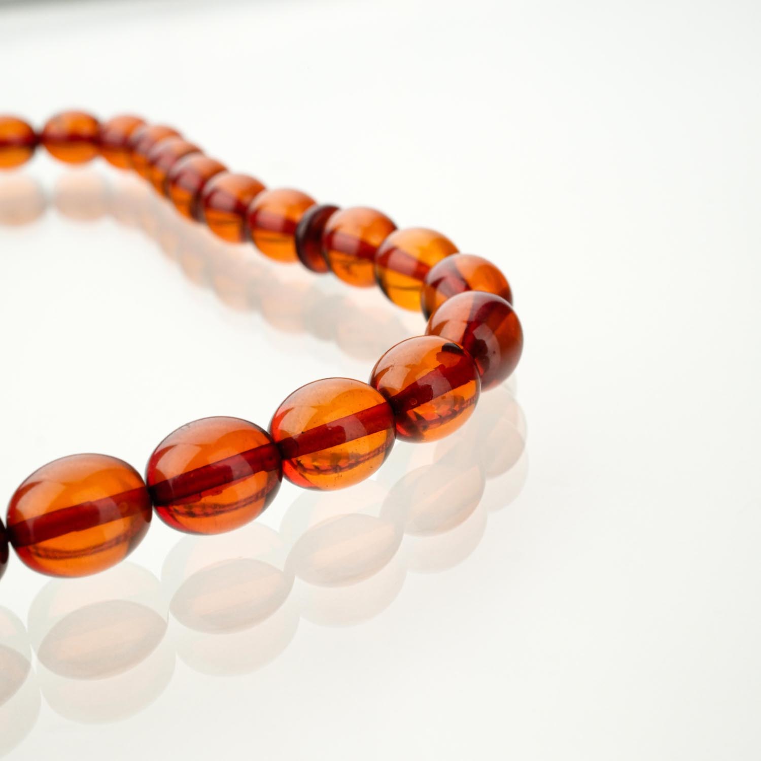 مسبحة-كهرمان-أصلي-فضة-925 مسبحة من الكهرمان الأصلي المعتمد بخرز مقاس 7.5x9 مم معروضة على سطح أبيض