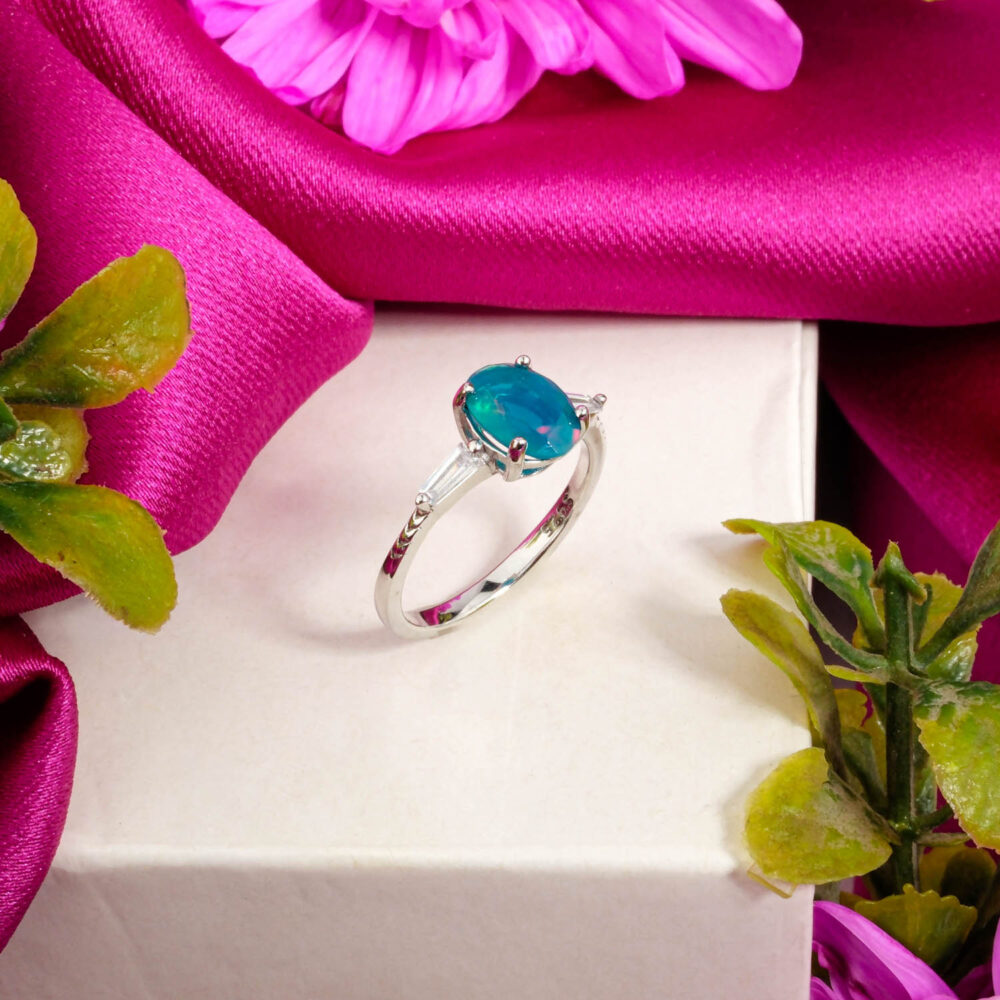 A designer 925 sterling silver ring featuring an oval Blue Opal stone with a swirling split-shank setting.