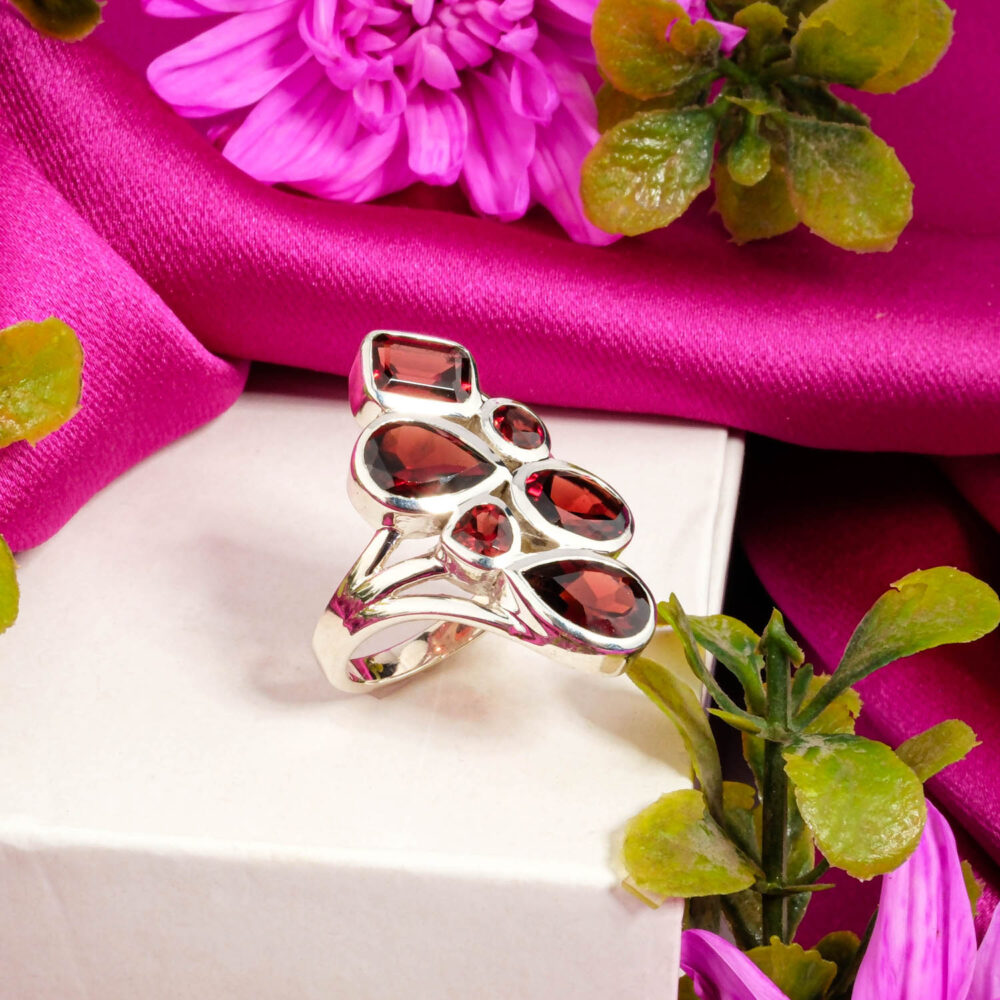 A designer 925 sterling silver ring featuring a cluster of multi-shaped deep red Garnet stones (pear, oval, rectangle).
