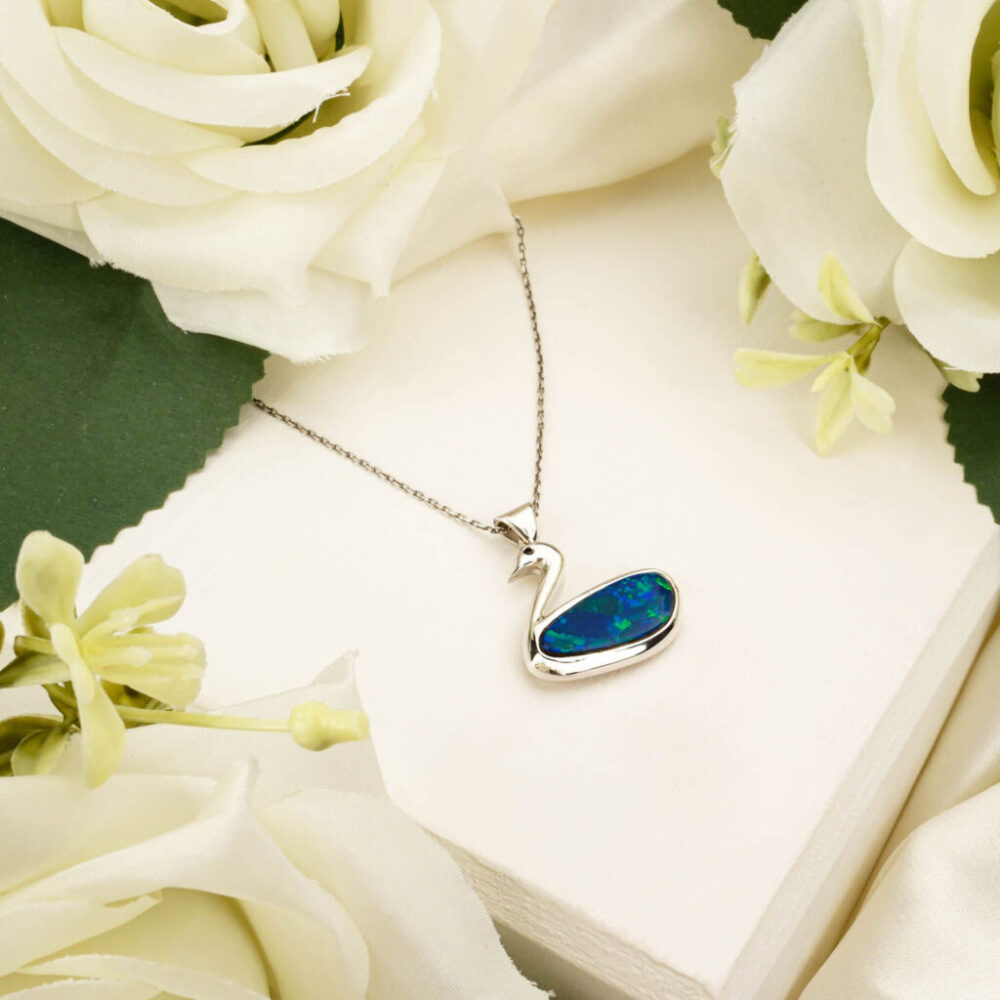 Australian Boulder Opal pendant in a silver swan design on white background