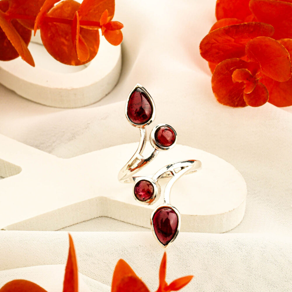 925 sterling silver Toi et Moi ring featuring two teardrop red garnet gemstones on white background