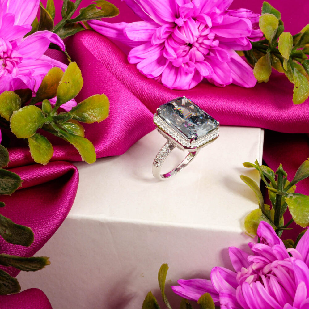 A luxurious women's statement ring in 925 sterling silver featuring a large, rectangular ice-cut stone surrounded by a halo.