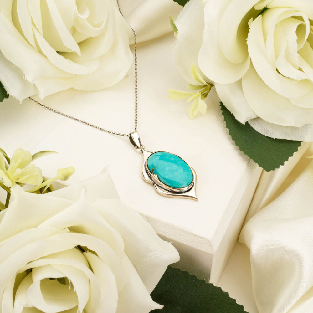 Handcrafted unisex pendant necklace featuring a genuine Persian turquoise gemstone in 925 sterling silver on white