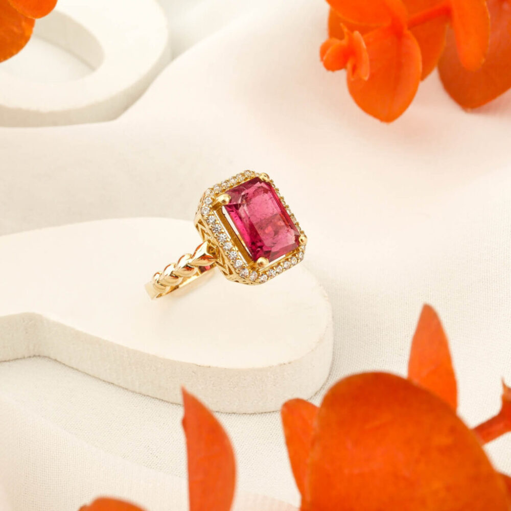 Emerald cut Rubellite Tourmaline ring with twisted 14K gold band and halo