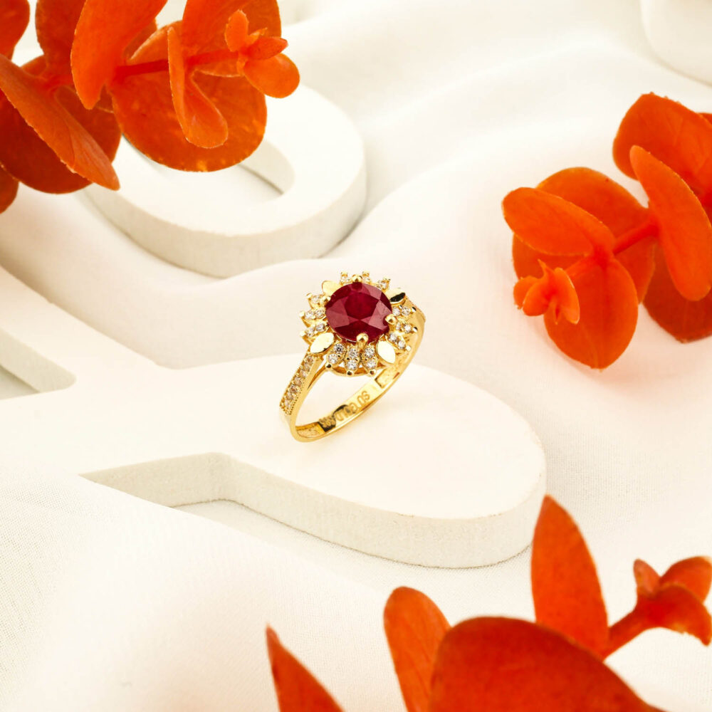 Natural ruby ring in 14K gold with floral halo design on display