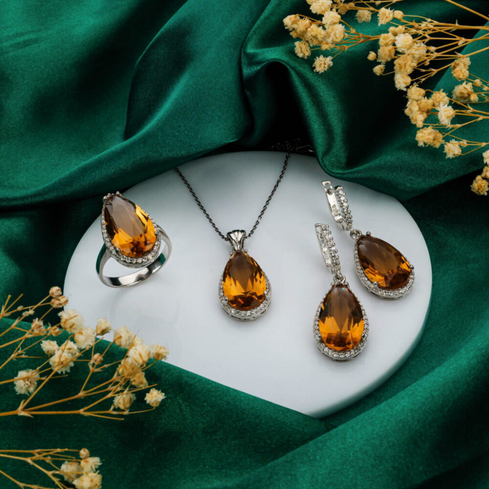 Complete silver jewelry set with color-changing Zultanite necklace, ring, and earrings on black background