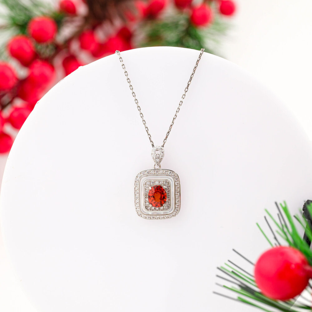 A designer 925 sterling silver necklace featuring a cushion-shaped pendant with an Orange Sapphire and Mother of Pearl border.