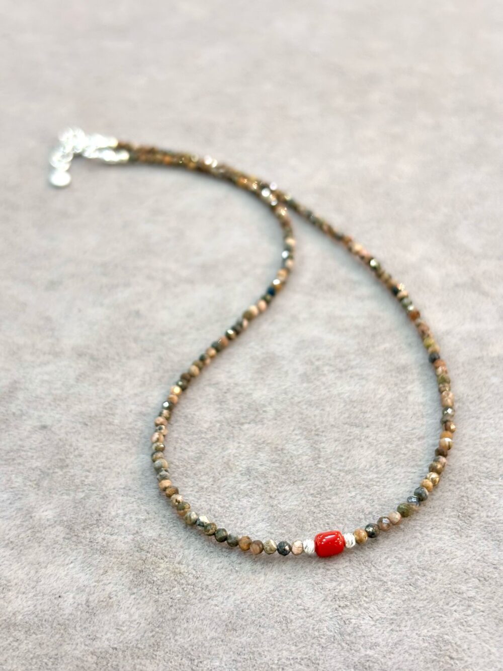 Faceted earthy rhodochrosite beaded necklace with red coral center bead