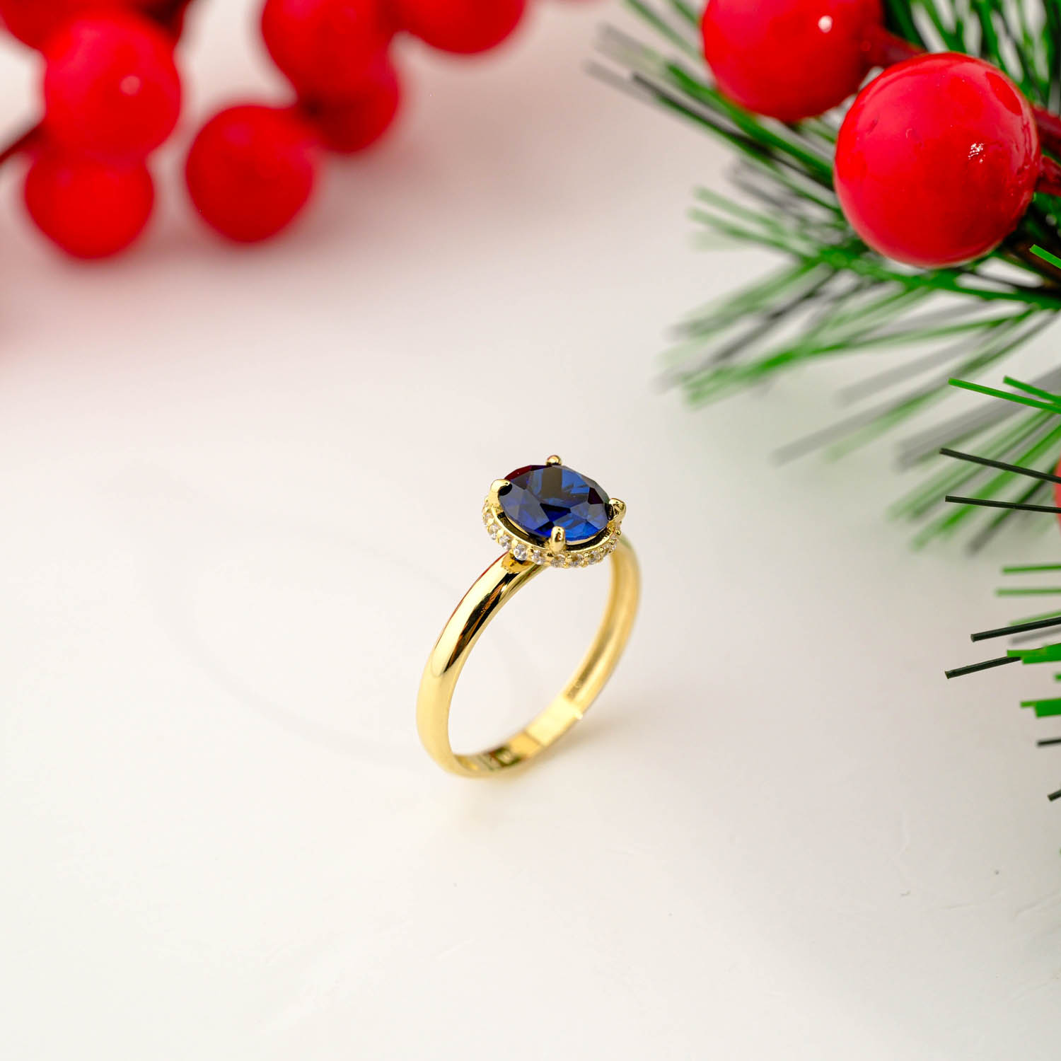 14k yellow gold solitaire ring featuring a round dark blue sapphire with hidden halo details under the setting