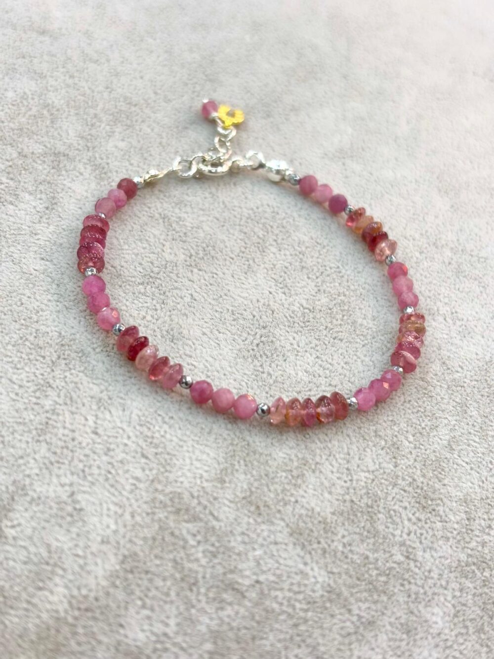 Natural faceted pink tourmaline beaded bracelet with silver spacers and gold flower charm