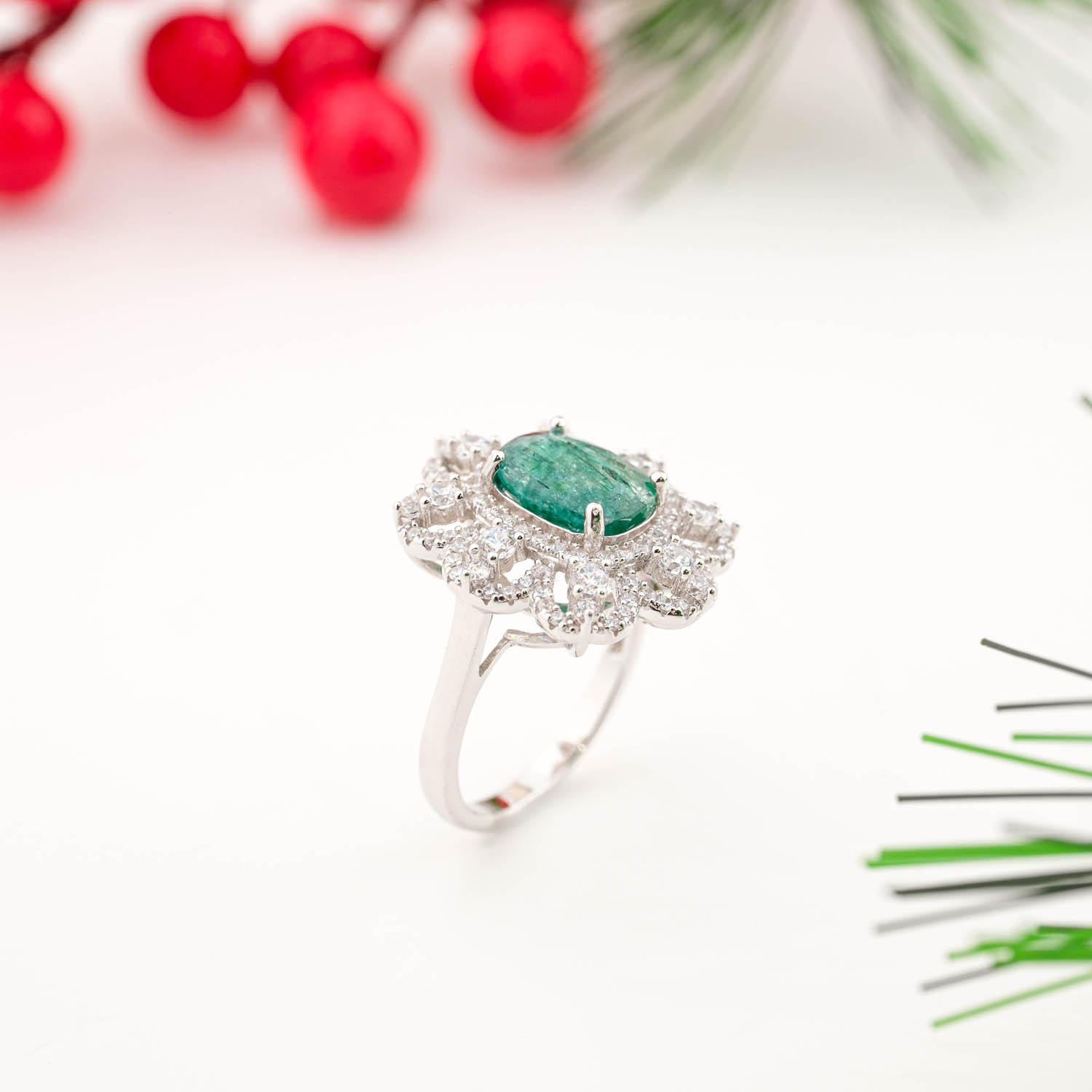 925 sterling silver ring featuring a natural oval emerald surrounded by a sparkling multi-tiered crystal floral halo