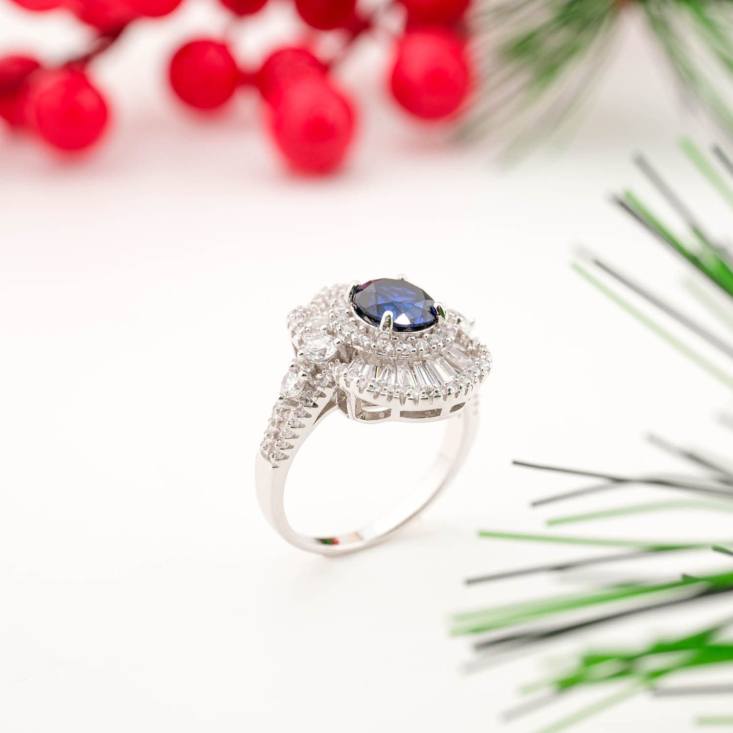 925 sterling silver ring featuring a natural oval blue sapphire surrounded by a sunburst halo of baguette and round crystals