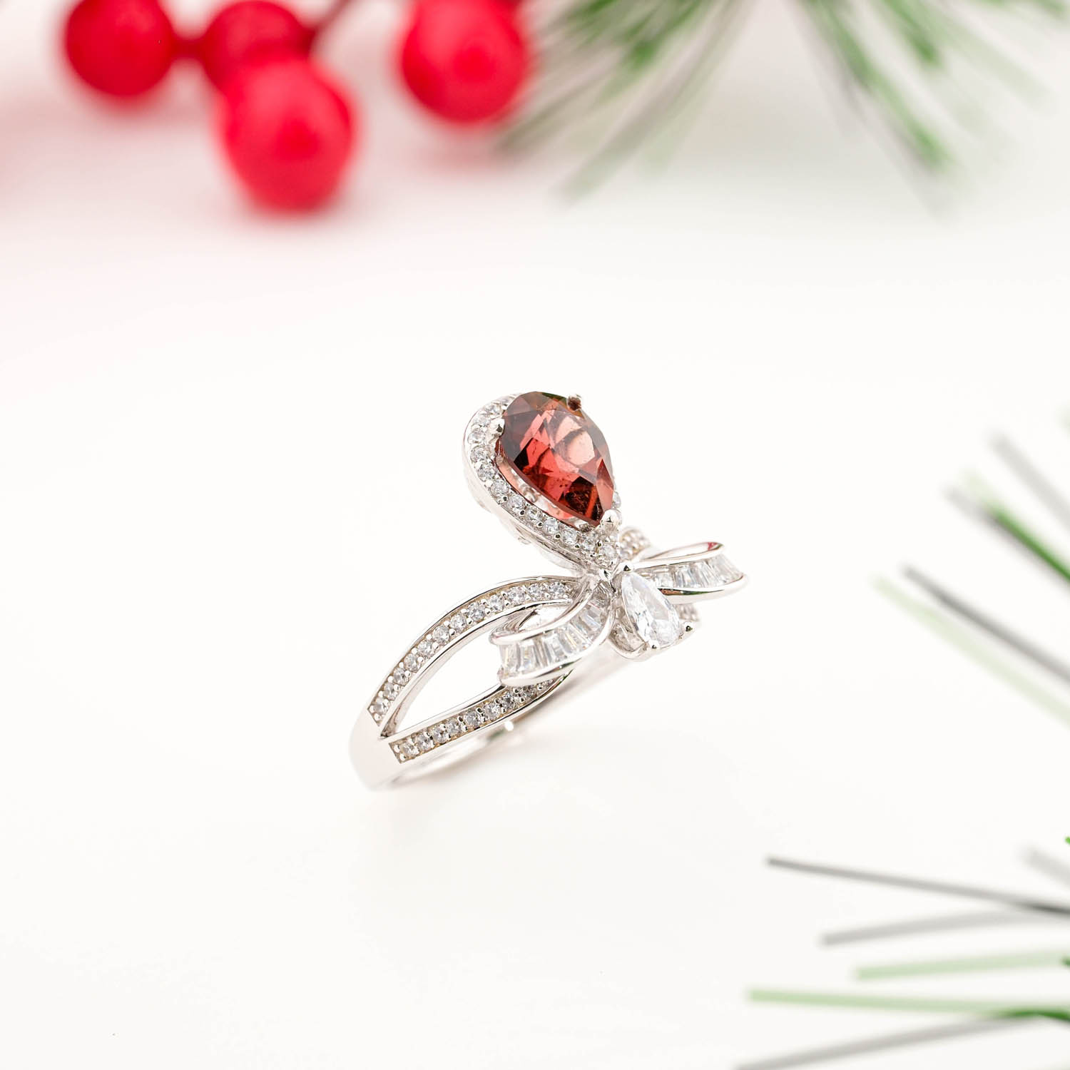 925 sterling silver ring featuring a natural pear cut pink tourmaline in an asymmetrical ribbon bow design with crystal accents