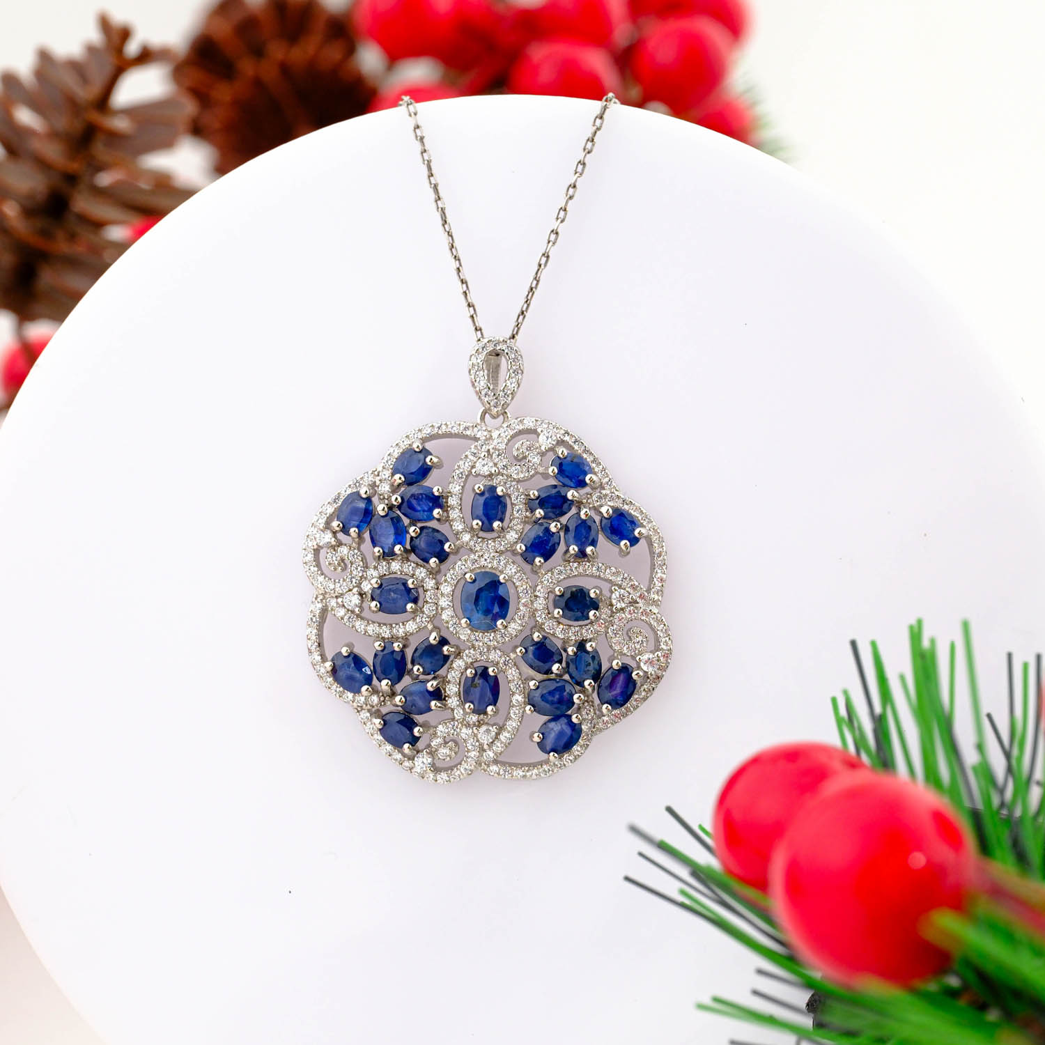 925 sterling silver necklace featuring an intricate floral mandala pendant set with multiple natural blue sapphires and pave crystals