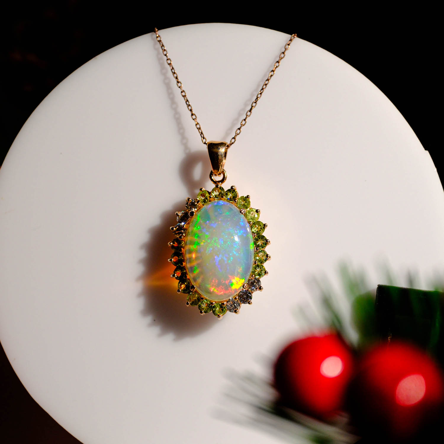 Gold plated 925 sterling silver pendant necklace featuring a VIP quality oval opal with rainbow flashes surrounded by a green peridot and swarovski crystal halo