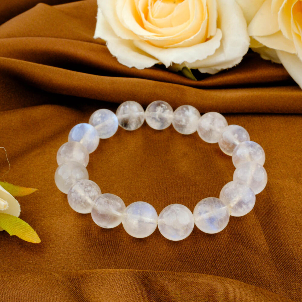 Premium 6A grade natural moonstone beaded bracelet with 11 to 12 mm smooth round stones featuring blue adularescence on brown fabric